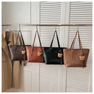 Dettaglio di grandi borse shopper in quattro colori retrò con ciondoli a forma di orso