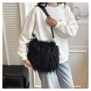 Detail of adjustable leather strap and fluffy black faux fur texture on a shoulder bag