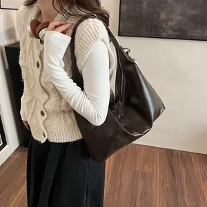 Retro large-capacity faux leather shoulder bag in dark coffee brown worn by model