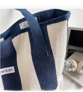 Detail of blue and white striped canvas tote featuring a Bateleur brand woven label