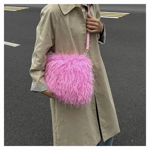 Detail shot of bright pink faux fur crossbody bag with adjustable slim strap on a trench coat