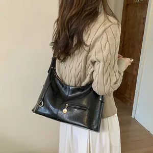 Classic black vintage shoulder bag with oil wax leather texture and gold hardware details