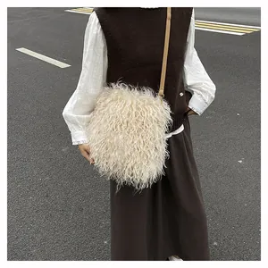 Detail of fluffy cream plush crossbody bag with a slim dark brown leather strap