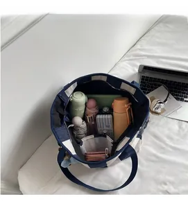 Detail showing the spacious interior compartments of the striped canvas tote bag