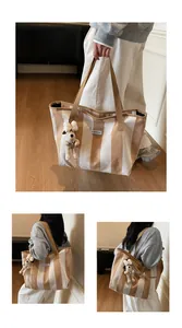 Detail showing striped canvas tote bag with Le Bateleur woven label and cute plush dog charm