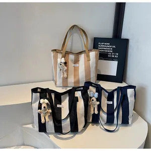 Three striped canvas tote bags in brown, blue, and black with cute dog plush charms