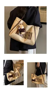 Detail of light beige suede tote bag with brown MACAORI logo and bear charm pendant