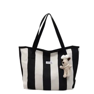 Minimalist black and white striped canvas tote bag with Le Bateleur logo and puppy charm
