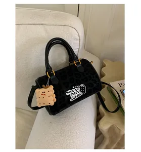 Detail of leopard print faux fur Boston bag with plush cookie charm and embroidery