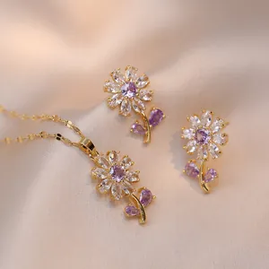 Elegant gold flower jewelry set with purple zircon necklace and earrings on satin