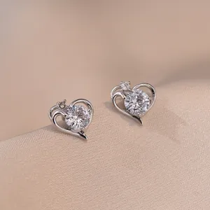 S925 silver heart stud earrings with dancing zircon stones on champagne satin fabric