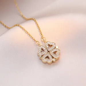 Collana a quadrifoglio in titanio oro con petali a cuore e diamanti su seta champagne