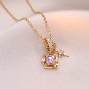Collier doré élégant avec pierre carrée rose et détails d'étoiles sur soie blanche