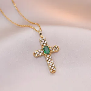 Collier croix dorée avec pierre centrale vert émeraude et zircons sur soie rose