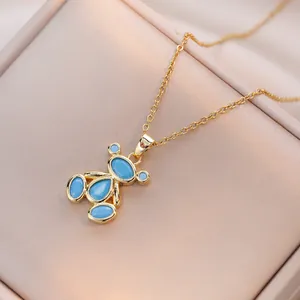 Chic golden bear necklace with blue zircon pendant on a beige jewelry display box