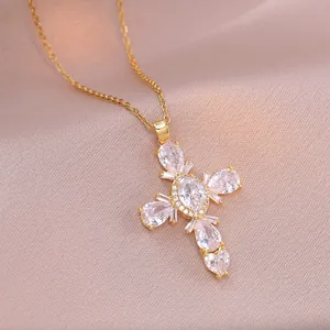 Collier avec pendentif croix dorée et zircons brillants sur fond de soie rose
