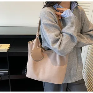 Dettaglio della grande borsa tote in pelle scamosciata albicocca con portamonete tondo