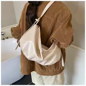 Detailed back view of a beige hobo tote bag with pleated texture and adjustable strap