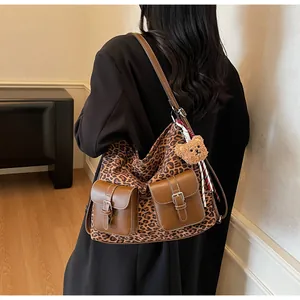 Leopard print crossbody bag with dual front pockets and plush bear charm detail