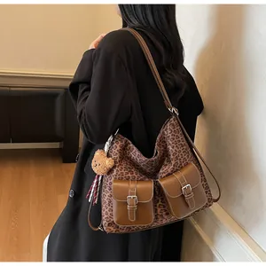 Detail of vintage leopard print crossbody bag with dual pockets and plush bear charm