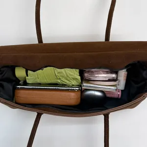Brown suede tote bag with top zipper and slim shoulder strap for daily commuting