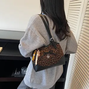 Chic leopard print tote bag with black leather straps and heart charm detail