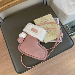 Pink suede boot-shaped crossbody bag with white faux fur trim and glove charm
