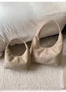 Size comparison of large and small khaki suede hobo bags in a minimalist home setting