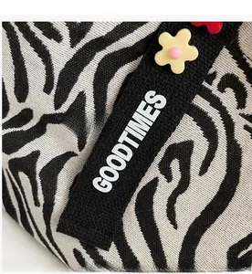 Detail of zebra stripe canvas bag with GOODTIMES logo and 3D floral accents