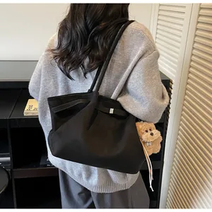 Détail du sac cabas noir en toile avec pendentif ours et boucles latérales ajustables