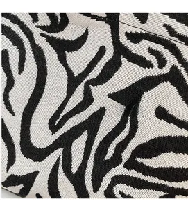 Close-up of the black and white striped knit texture and durable woven fabric of the bag