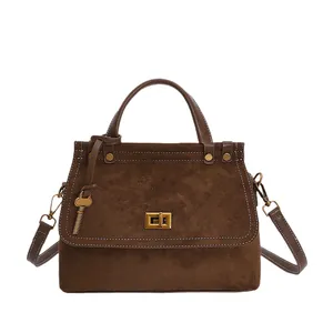 Brown vintage matte suede handbag with contrast stitching and gold metal twist lock