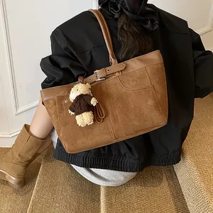 Vintage dark brown suede tote bag with leather straps and bear charm shown on model