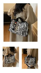 Detail of zebra stripe canvas bag with GOODTIMES lanyard and colorful floral charms