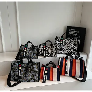 Detail of canvas tote bags in floral, zebra and stripe patterns with magnetic closure