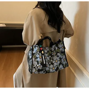 Detail of floral quilted tote bag featuring webbing handles and detachable shoulder strap