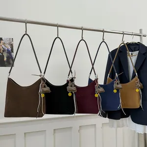 Minimalist faux suede shoulder bags in five colors with cute charms on metal rack
