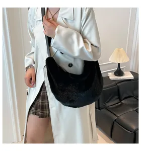 Sac croissant chic en fausse fourrure noire porté avec un trench-coat blanc moderne