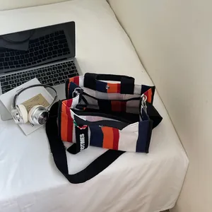 Striped canvas tote bag with adjustable shoulder strap and multi-compartment design