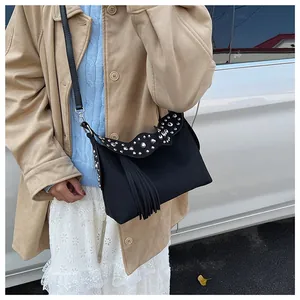 Detail of bohemian black crossbody bag with silver studs and elegant fringe decoration