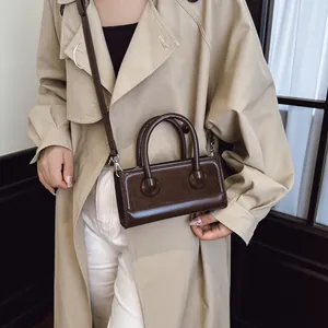 Retro dunkelbraune Handtasche aus Wildleder-Stitch am Modell für ein elegantes Outfit