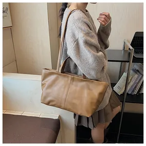 Detail of a brown PU leather tote bag showing dual straps and premium texture finish