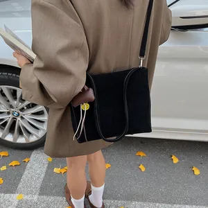 Borsa tote minimalista in pelle scamosciata nera opaca con ciondolo smiley e blazer