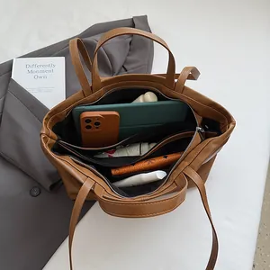Brown large tote bag interior view showing multi-compartment storage and shoulder strap