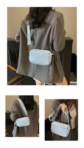 Detail van lichtblauwe crossbodytas met trendy brede schouderband met geometrisch patroon