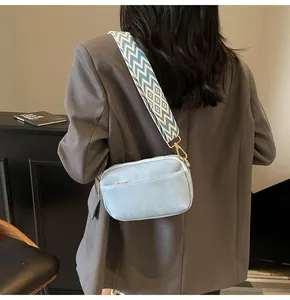 Detail van lichtblauwe crossbodytas met vintage geometrisch patroon brede schouderband
