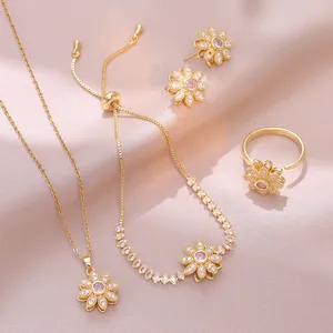 Goldschmuck-Set mit Gänseblümchen, rosa Steinen und Zirkonia auf rosa Seidenstoff