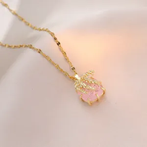 Elegante goldene Halskette mit rosa Blütenanhänger und Zirkonia auf weichem Seidenstoff