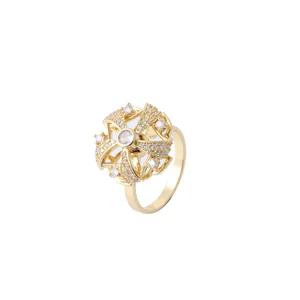 Macro detail of rotating gold flower pendant with sparkling zircon micro-pave setting