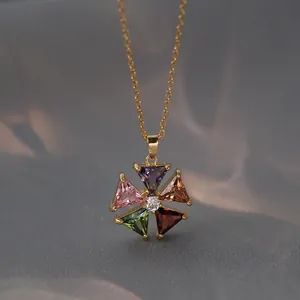 Collier en acier titane doré avec un pendentif fleur en zircon coloré sur soie grise